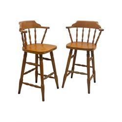 Pair of late 20th century beech bar stools, with curved top rail and turned spindle back, shaped seat over four turned legs united by multiple stretchers