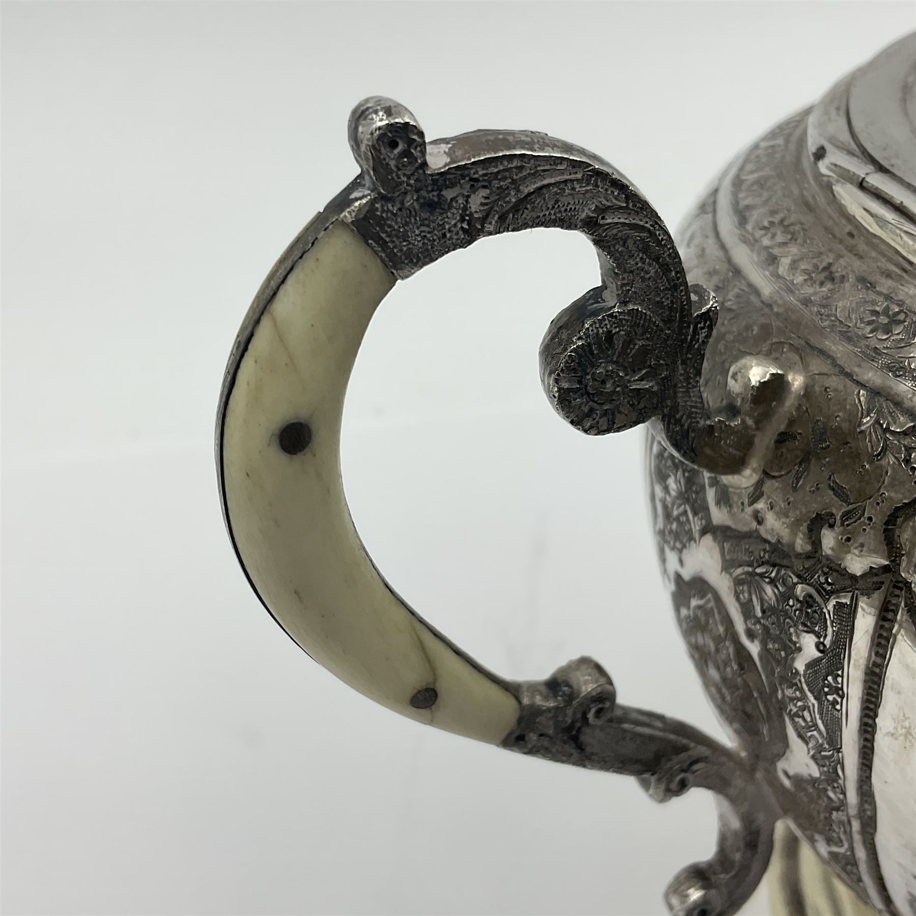 Early/mid 20th century Persian silver tea service, comprising circular serving tray, teapot, twin handled sucrier and cover, milk jug, five tea glasses with six silver holders, six tea spoons, and pair of sugar tongs, each profusely chased with foliate arabesque decoration, each bearing marks including 84 for 840 fineness, tray D40cm, teapot H16cm
