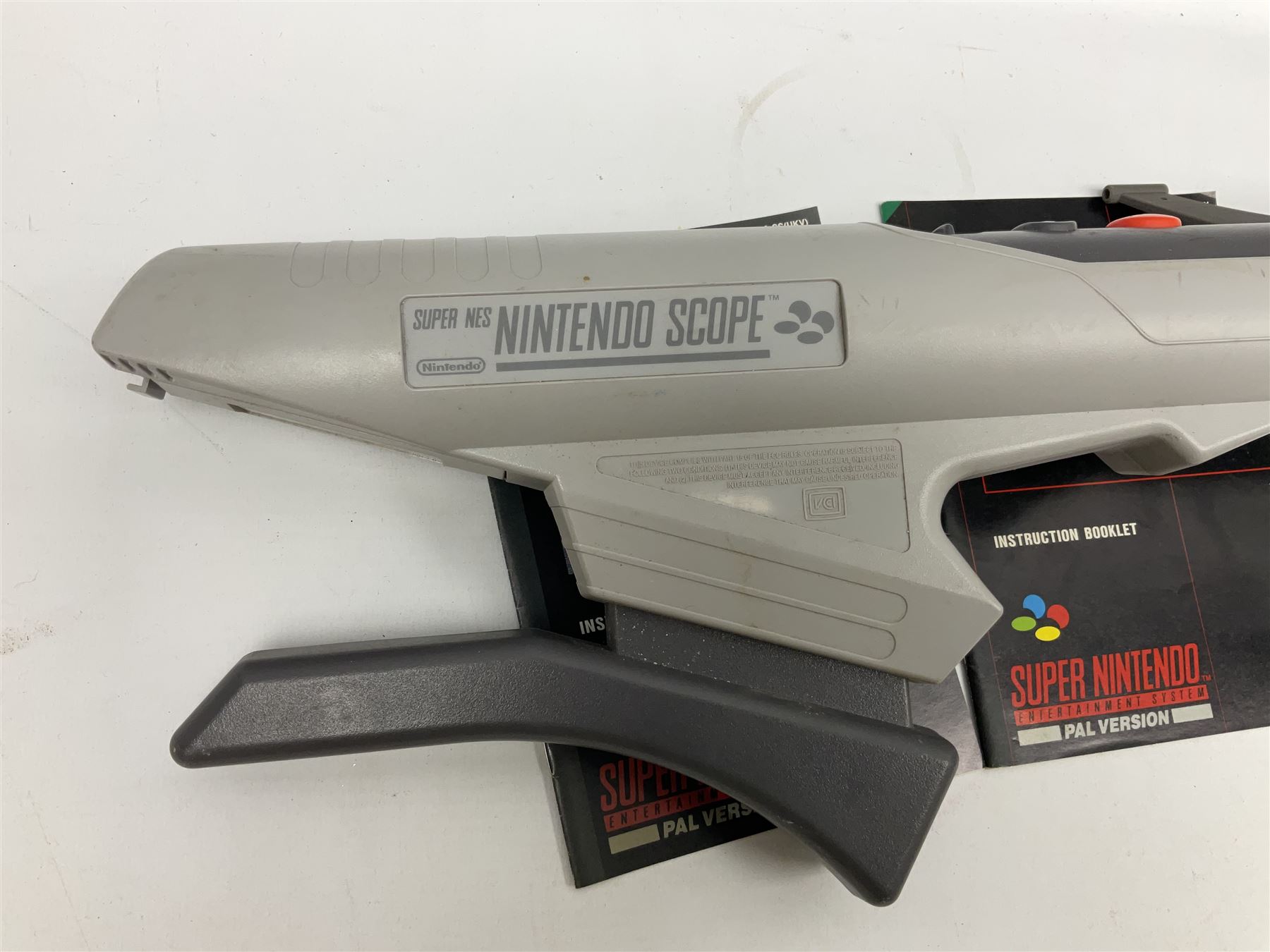 Two Super Nintendo Entertainment System (PAL) controllers, accessories and games. Super NES Game Commander with original box and instruction booklet, Super NES Nintendo Scope (1992) transmitter gun, receiver, Super NES Nintendo Scope 6 game with original instruction booklets. Further games to include ‘The Legend of Zelda a Link to the Past’, ‘Super Mario World’, ‘Super Mario Kart’, ‘The Lawnmower Man’, and ‘Exhaust Heat’, all with original instruction booklets. ‘PowerMonger’ and Disney’s ‘Aladdin’ game cartridges only 