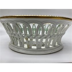 Pair of 19th century German openwork chestnut baskets, with twin handles and scrolling gilt border and star rim, painted to the centre with birds and insects, D22cm 