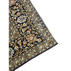 Persian Kashan indigo ground carpet, floral pattern light blue ground central medallion and spandrels, the fielding decorated with interlacing leafy branches and palmettes, the repeating floral pattern border enclosed within guard stripes