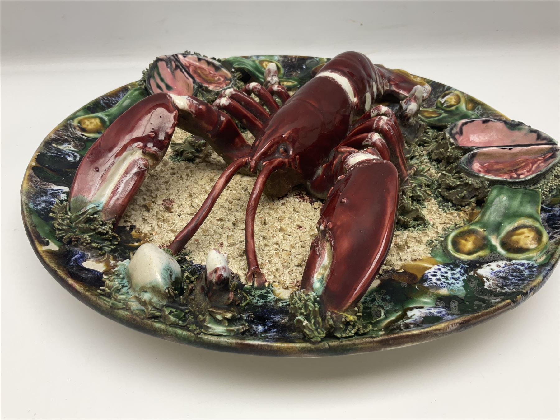 Two 20th Century Portuguese Palissy style Majolica wall plates, one depicting a crab, the other a lobster each to the centre modelled in relief surrounded by encrustations and shells, both with impress marks beneath, D34cm