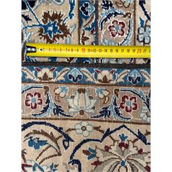 Central Persian Nain carpet, the deep blue field with finely drawn scrolling palmettes and flowering vines around a central ivory and sky blue rosette medallion, enclosed by an ivory border of interlaced floral arabesques and lotus forms between multiple guard stripes, from the region of Nain