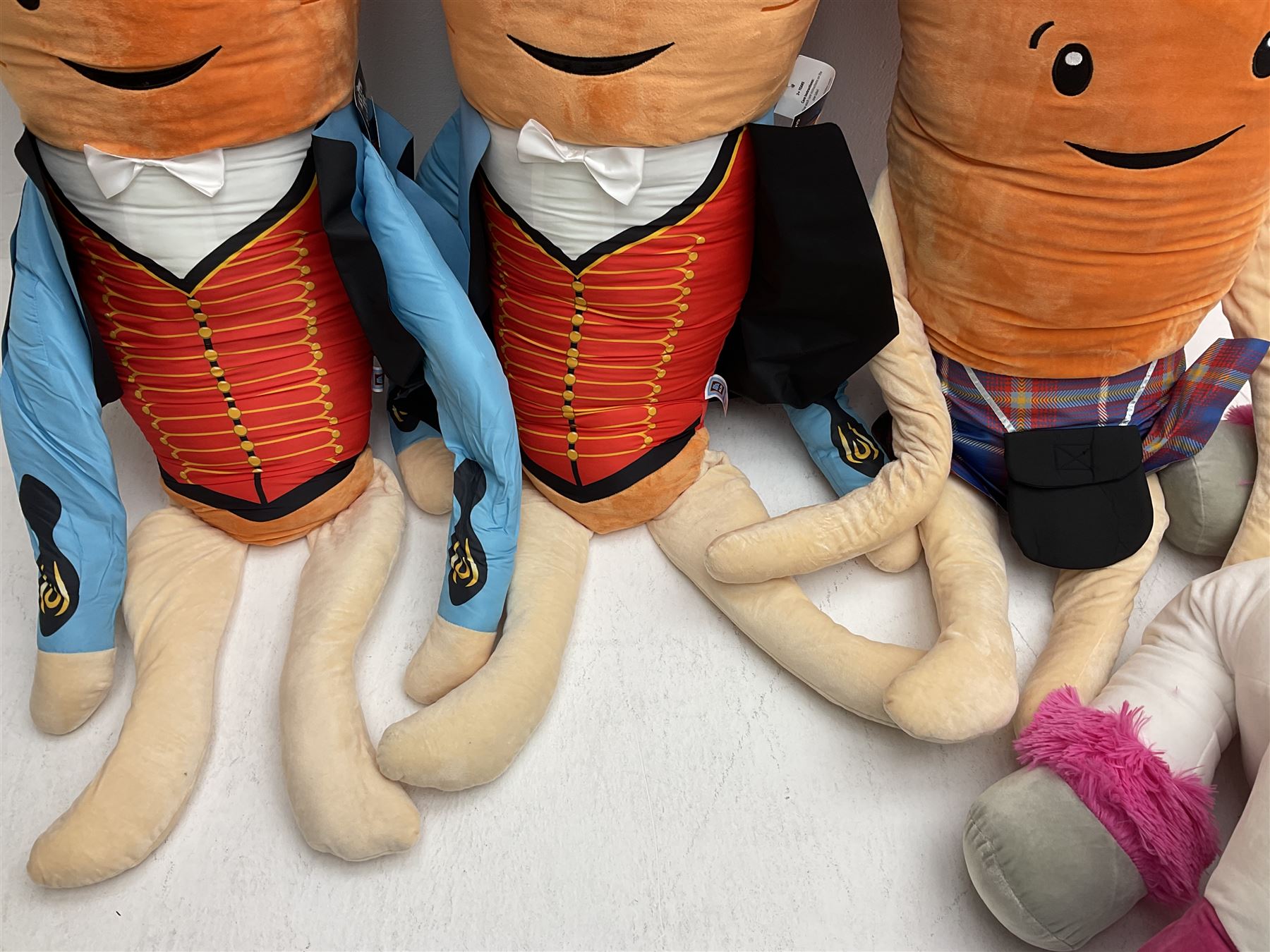 Three large ALDI Kevin carrots and giant unicorn stuffed toy together with quantity of smaller carrots