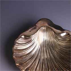 Edwardian silver butterdish in the form of a clam shell and upon four bun feet, hallmarked Williams Birmingham Ltd, Birmingham 1905, with a silver plated butter knife, contained within a fitted tooled leather case, width of dish 13cm