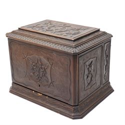 Late 19th century cave à liqueur black forest style decanter box, with carved naturalistic decoration, lifting top and fold out side panels, the interior fitted with four decanters and sixteen glasses, the smaller glasses with applied painted decoration, the others with etched design, with key, when closed overall W36cm x D29cm x H28cm 