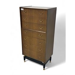 G-Plan teak tallboy, seven drawer chest with brass loop handles, ebonise base with adjustable brass terminals
