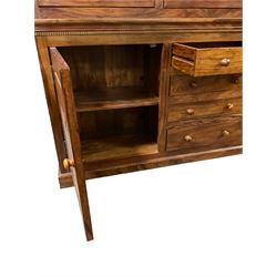 Large hardwood display wall unit, the upper section fitted with three glazed doors enclosing six shelves, the lower section fitted with four central drawers flanked by two panelled cupboards