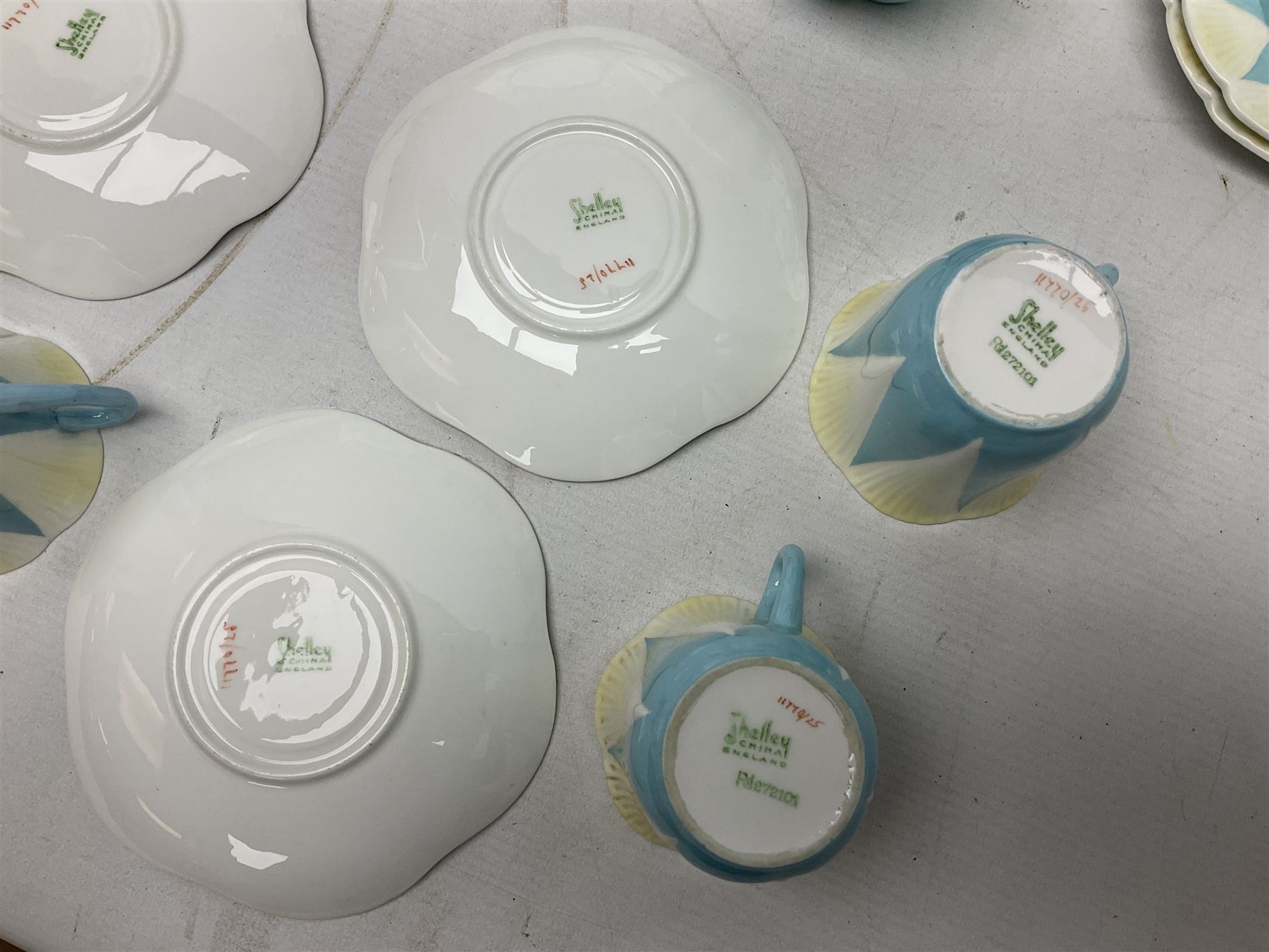 Shelley Dainty pattern tea wares, of lobed form with blue star decoration on merging white and yellow ground, comprising five teacups, five saucers, six tea plates, milk jug and cake plate, all with printed green mark beneath, some with painted pattern no 11770