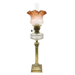 Victorian brass oil lamp, the square stepped base leading to a Corinthian column supporting a part slice cut clear glass reservoir, burner, clear glass chimney and foliate etched glass shade with amber rim, overall H80cm