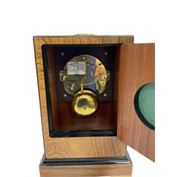 Knight & Gibbins London - 20th century 8-day marquetry inlaid mantle clock in rectangular case on a short plinth, glazed circular dial with Roman numerals and steel moon hands, two train striking movement with a floating balance escapement striking the hours and half hours on a bell, rear set and wound. With key.   