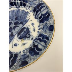 18th century Delft blue and white peacock pattern dish, painted with a fan of peacock feathers behind an urn of fruit and flowers, D34.5cm. 