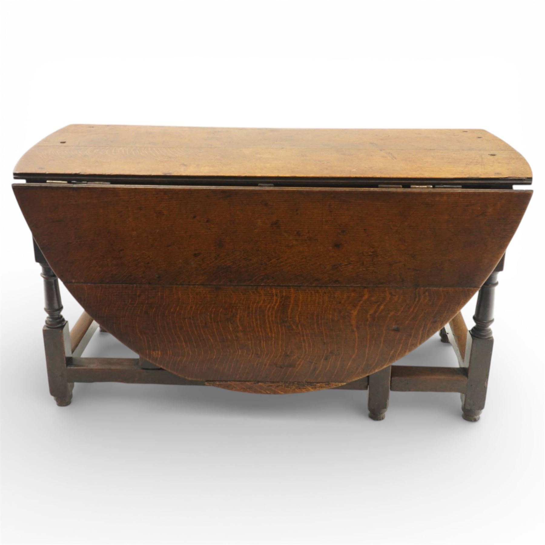 18th century large oak gateleg table, of plank top construction with visible dowels, with drop leaves to form an oval table 167cm in width, raised on block and turned supports