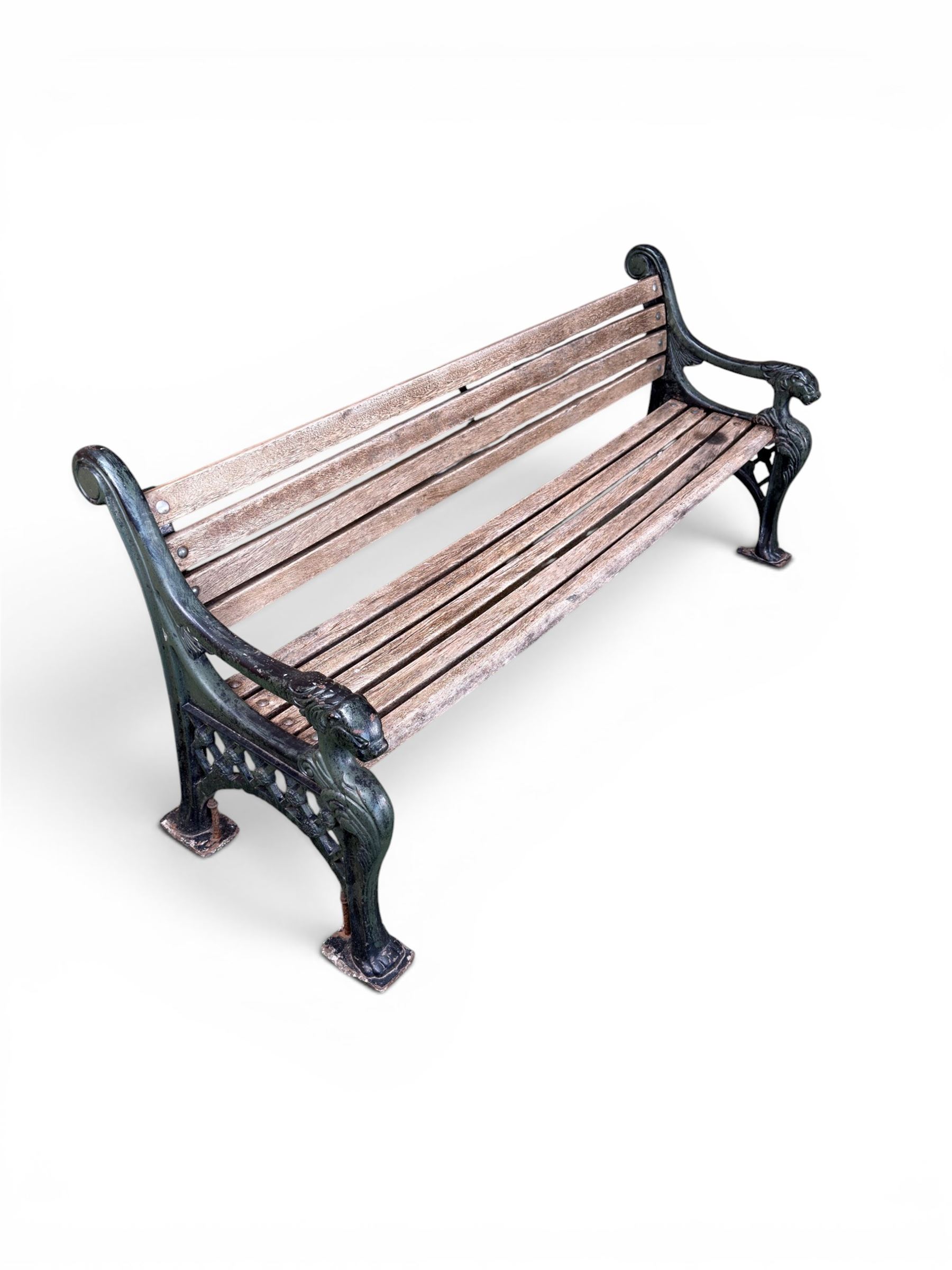 Neoclassical design cast iron and oak slatted garden bench, the twin end supports in the form of a Sphinx with acanthus carved knees and large paw feet, the pierced lattice bracket with Yorkshire rose motifs