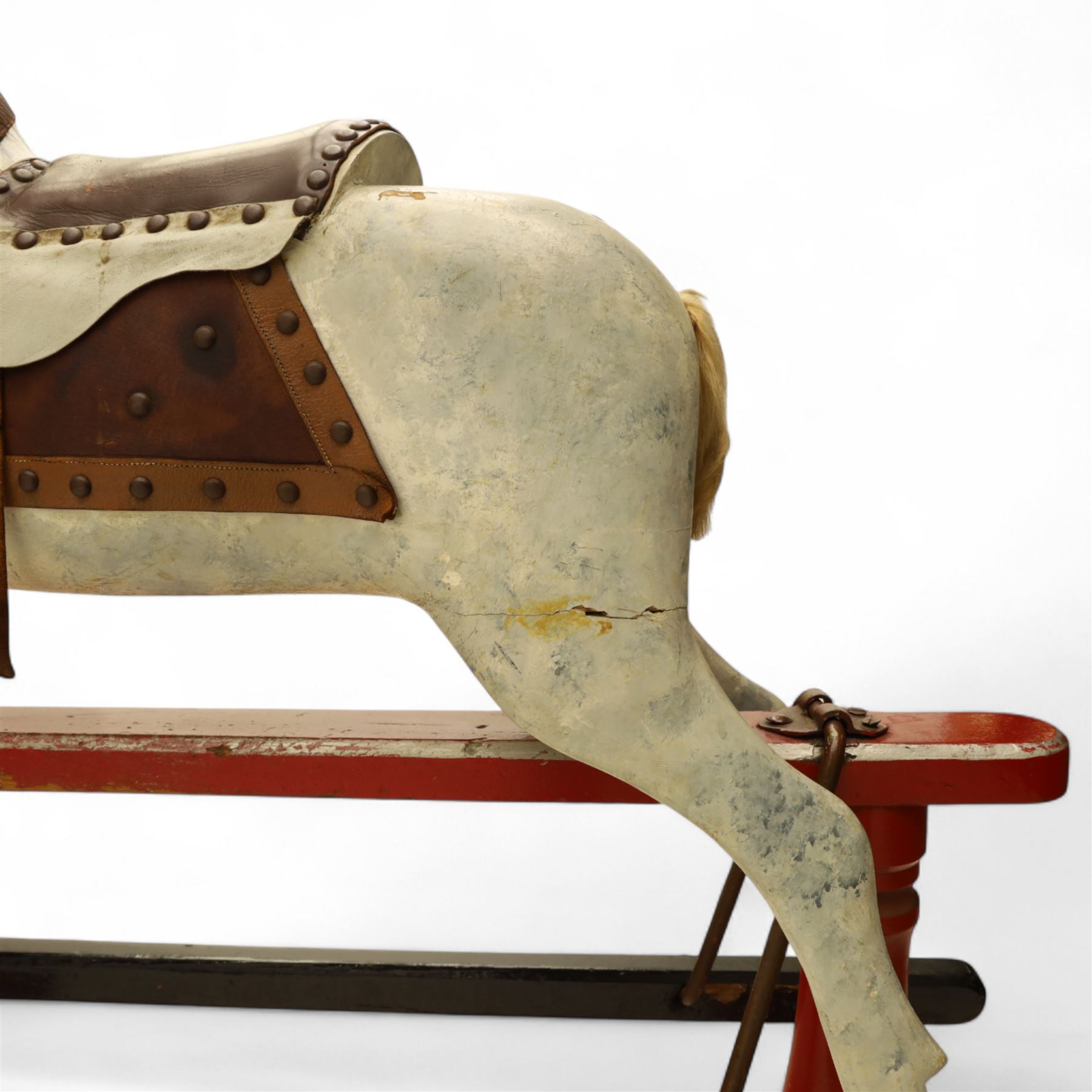 20th century carved and painted rocking horse, with original dappled paint finish, studded leather saddle and reins, on later red and black swing frame