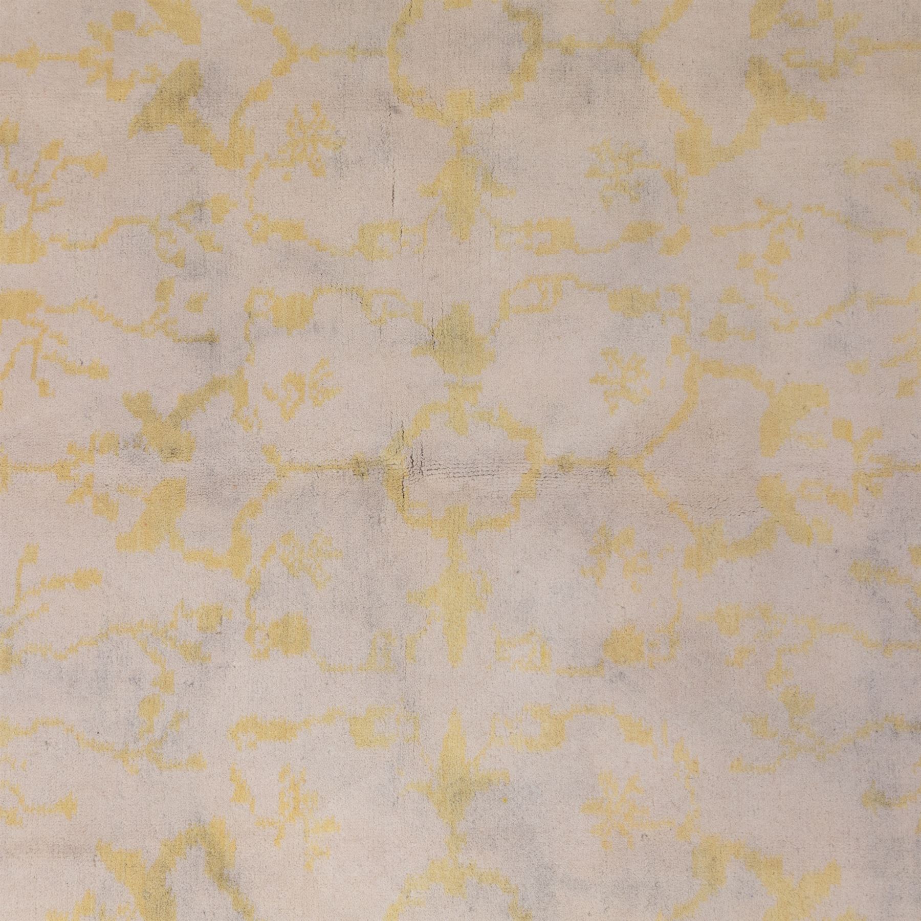 Tibetan wool rug, decorated with a pale cream ground and yellow all-over foliate design, enclosed by a broad yellow floral border and narrow inner guard band