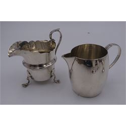 Victorian silver milk jug, of plain barrel form, with strap handle, hallmarked Jonathan Wilson Hukin & John Thomas Heath, London 1885, together with an Edwardian example, of helmet form, with central girdle and scroll handle, upon three pad feet, hallmarked Thomas Hayes, Birmingham 1904, a pair of 1930's peppers, of typical plain form, hallmarked London 1932, maker's mark indistinct, and a modern silver egg cup, hallmarked Turner & Simpson Ltd,  Birmingham 1956, approximate total silver weight 8.25 ozt (256.7 grams)