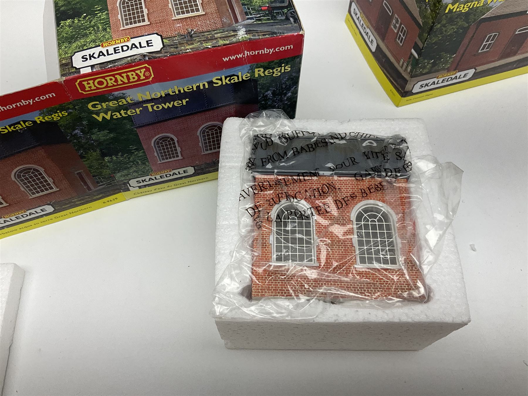 Hornby '00' gauge - nineteen Skaledale trackside buildings/accessories including R8542 Holly Farm Workshop, R9671 GWR Water Column and Crane, R8716 Upper Skaledale Main Building, R8657 Roundabout, R8993 Water Cleansing Tank, R8709 Fuel Oil Tanks, R8741 Purifiers, R9531 Magna Waiting Room etc; all but one boxed (19)
