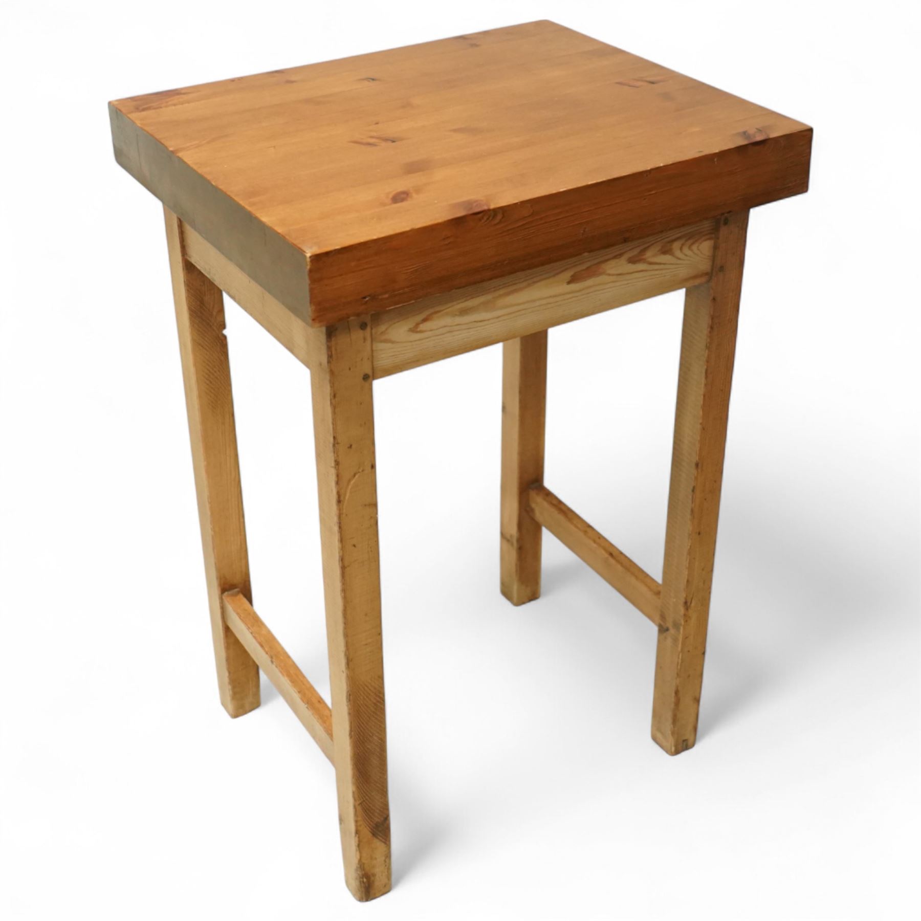 Mid-20th century pine butcher’s block, the thick laminated rectangular top raised on square supports united by side stretchers