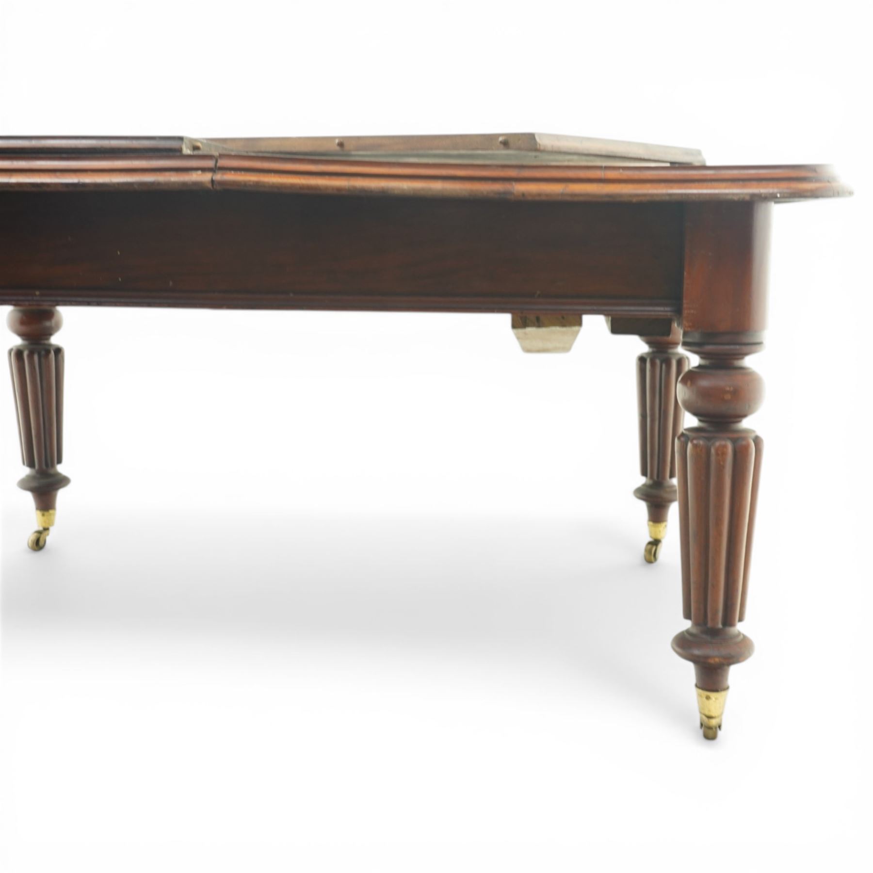 Victorian mahogany extending dining table, rounded rectangular top with moulded edge and two additional leaves, on four turned and fluted supports with brass caps and castors, extension mechanism beneath, in need of restoration