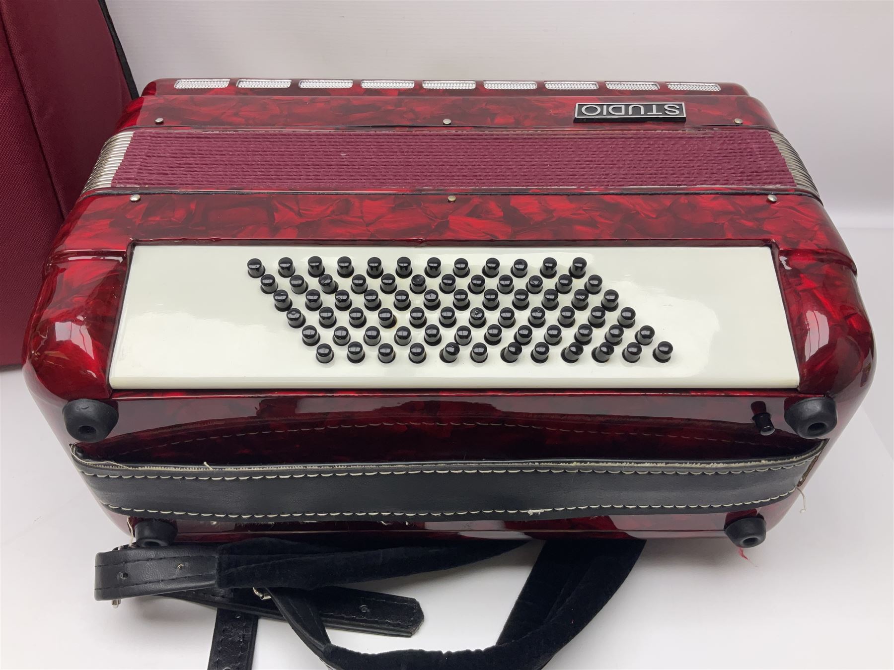 Hsinghai Studio piano accordion with red pearline finish, twenty keys and seventy-two buttons W44cm; in hard carrying case with additional The Music Room soft gig case