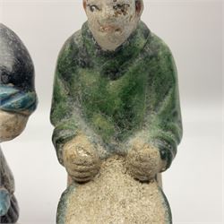 Three Chinese terracotta court attendant tomb figures, probably Ming Dynasty, two examples decorated in Sancai green glaze, the third example decorated in two tone blue glaze, each upon stepped square bases, tallest H22.7cm