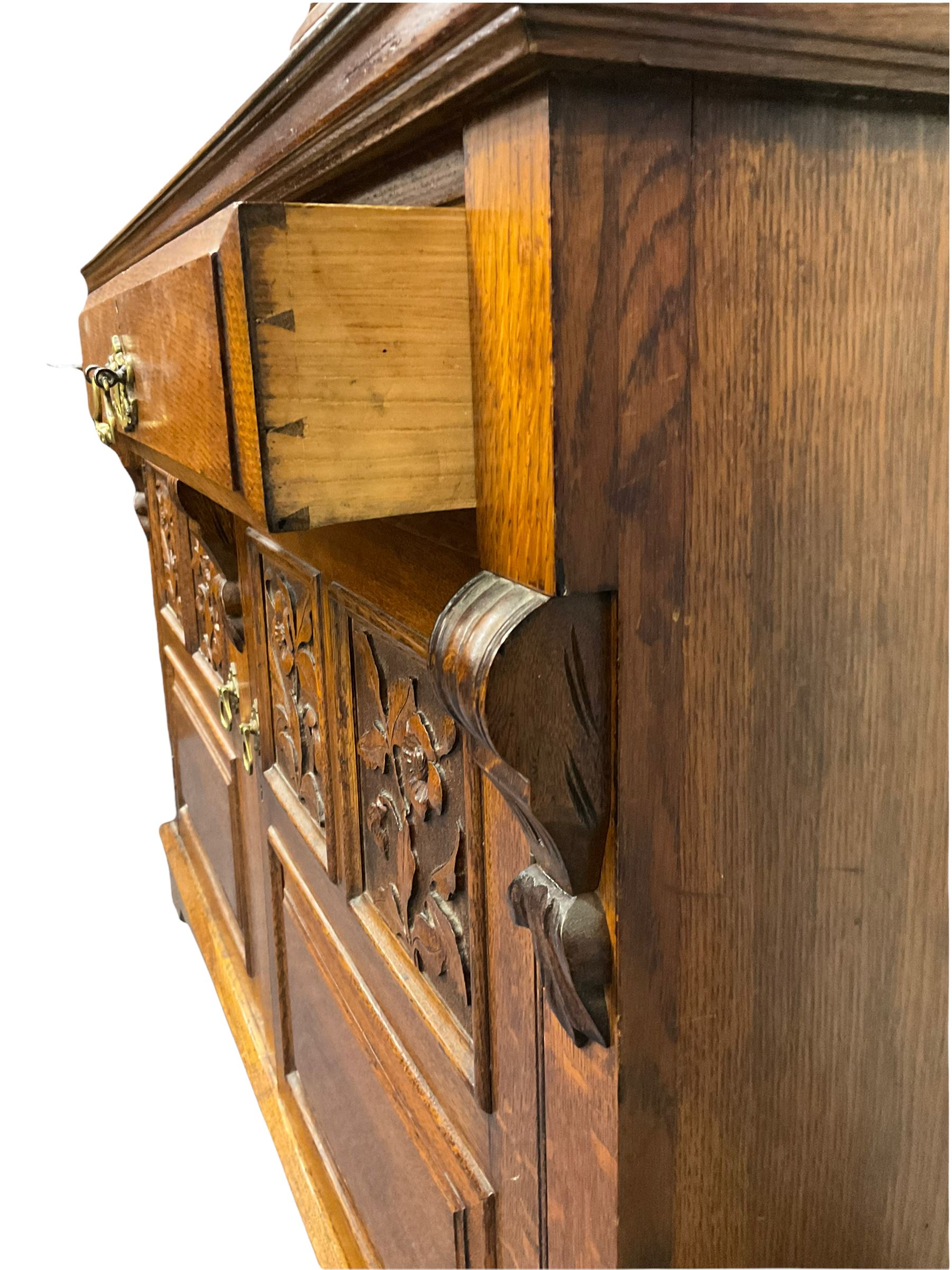 Edwardian oak mirror back sideboard, raised shaped pediment carved with acanthus leaves over Greek key frieze, bevelled mirror back, fitted with two drawers and two cupboards