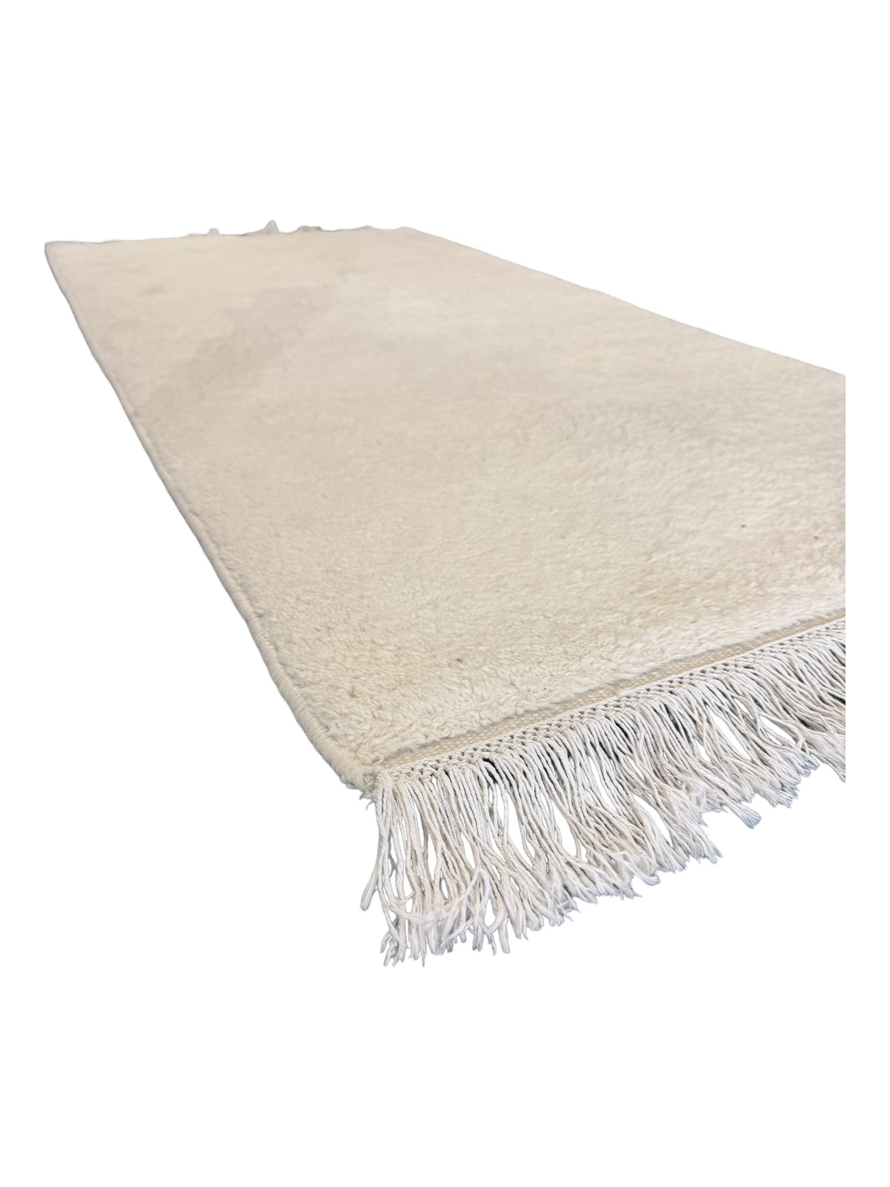 Contemporary Kayam hand-knotted Indian rug, plush wool pile in plain cream, ivory fringed edges on both sides 