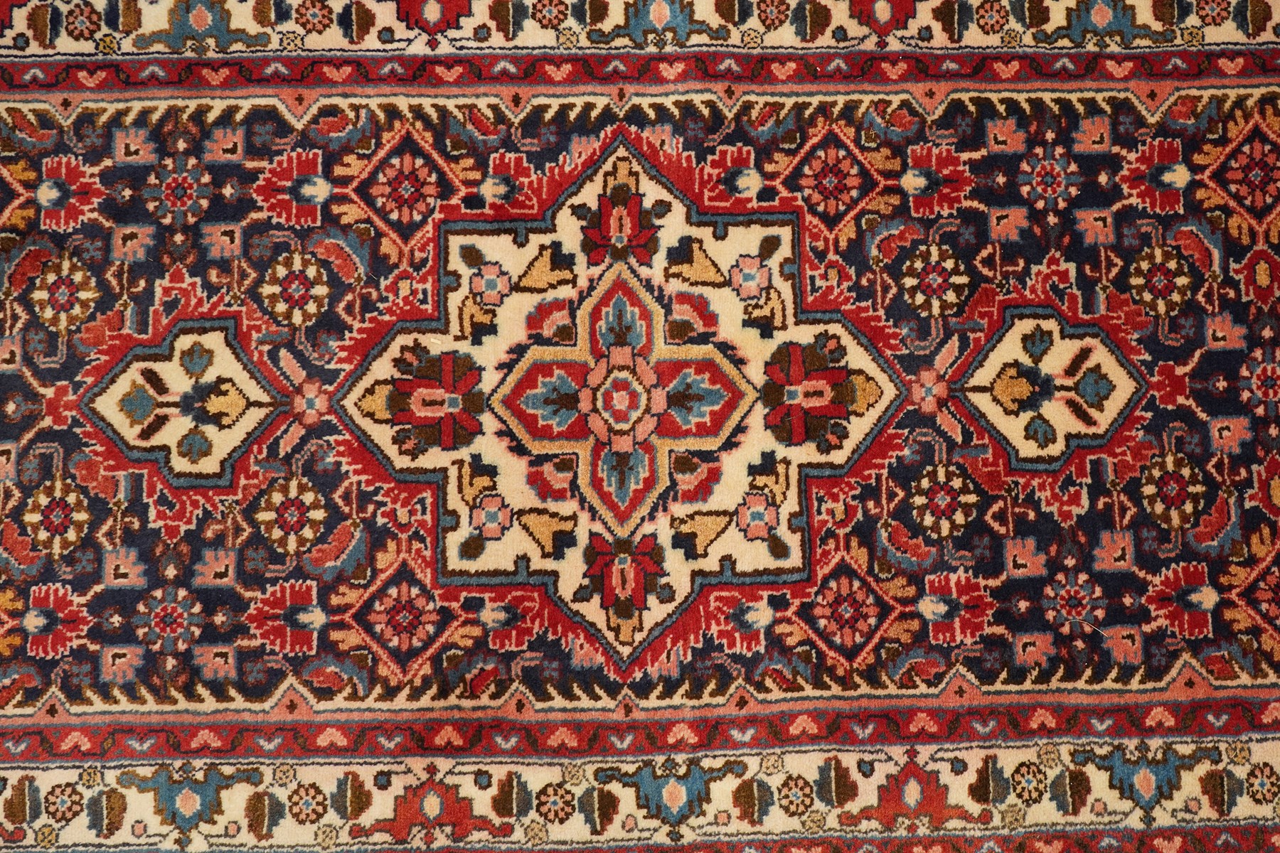 North-west Persian Malayer runner rug, the indigo ground decorated with ivory medallions and an all-over Herati pattern, red floral spandrels, enclosed by an ivory trailing floral border and crimson patterned guard stripes