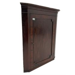 Georgian mahogany wall hanging corner cupboard, enclosed by panelled door with canted mould, green painted interior fitted with three shaped shelves