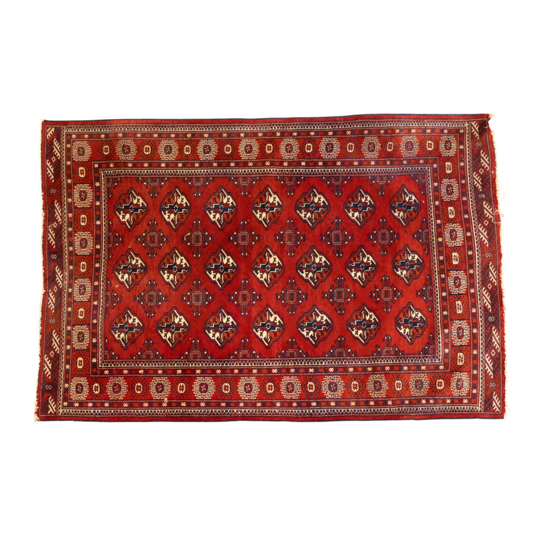 Three rugs,  comprising a Baluch rug in crimson ground, 179x97cm, a Tekke Bokhara rug in crimson ground, 201x132cm, and a Bokhara rug in ochre ground, 125x175cm 