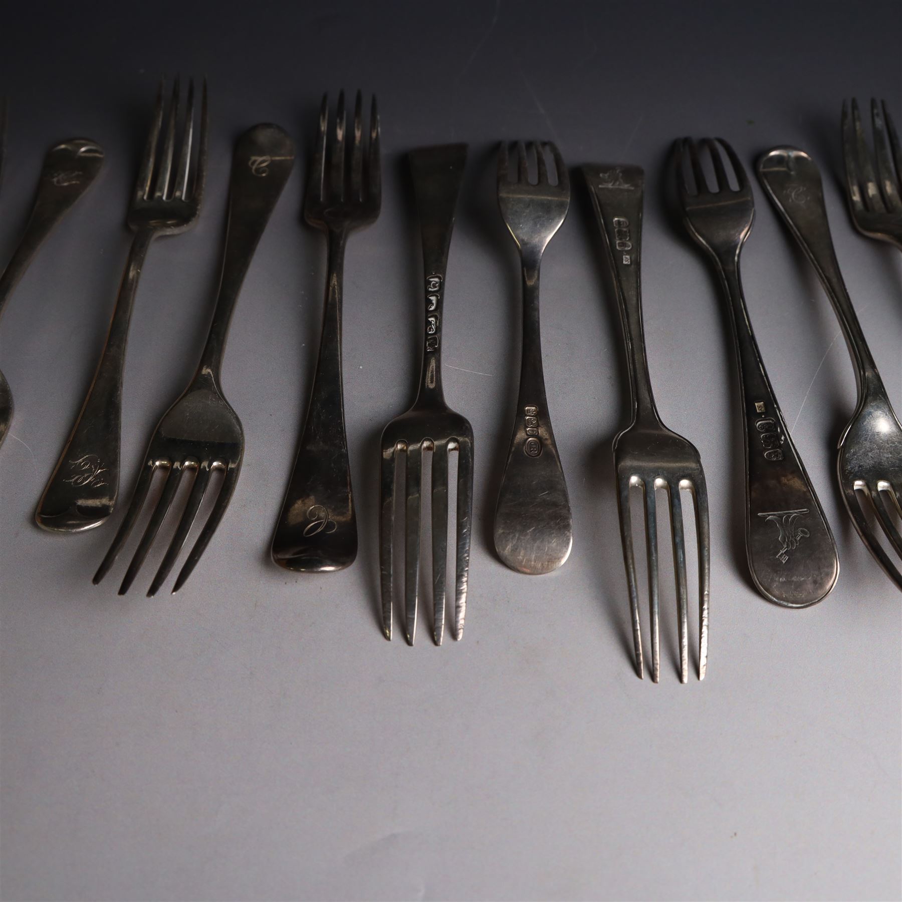 Seventeen Georgian and later silver Hanoverian pattern table and dessert forks, most with engraved initials to terminal and crests verso, including pair of table forks hallmarked William Sumner & Richard Crossley, London 1778