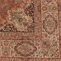 Persian vermillion ground Kashan rug, the busy field decorated with a central floral pole medallion, surrounded by trailing foliage and profusely woven floral patterns and bouquets, the dark indigo spandrels and multiple guard bands with similar floral decoration and stylised spandrels