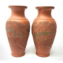 Pair of Chinese terracotta style vases, of baluster form with dragon decoration in low relief and fret border to rim, H25cm