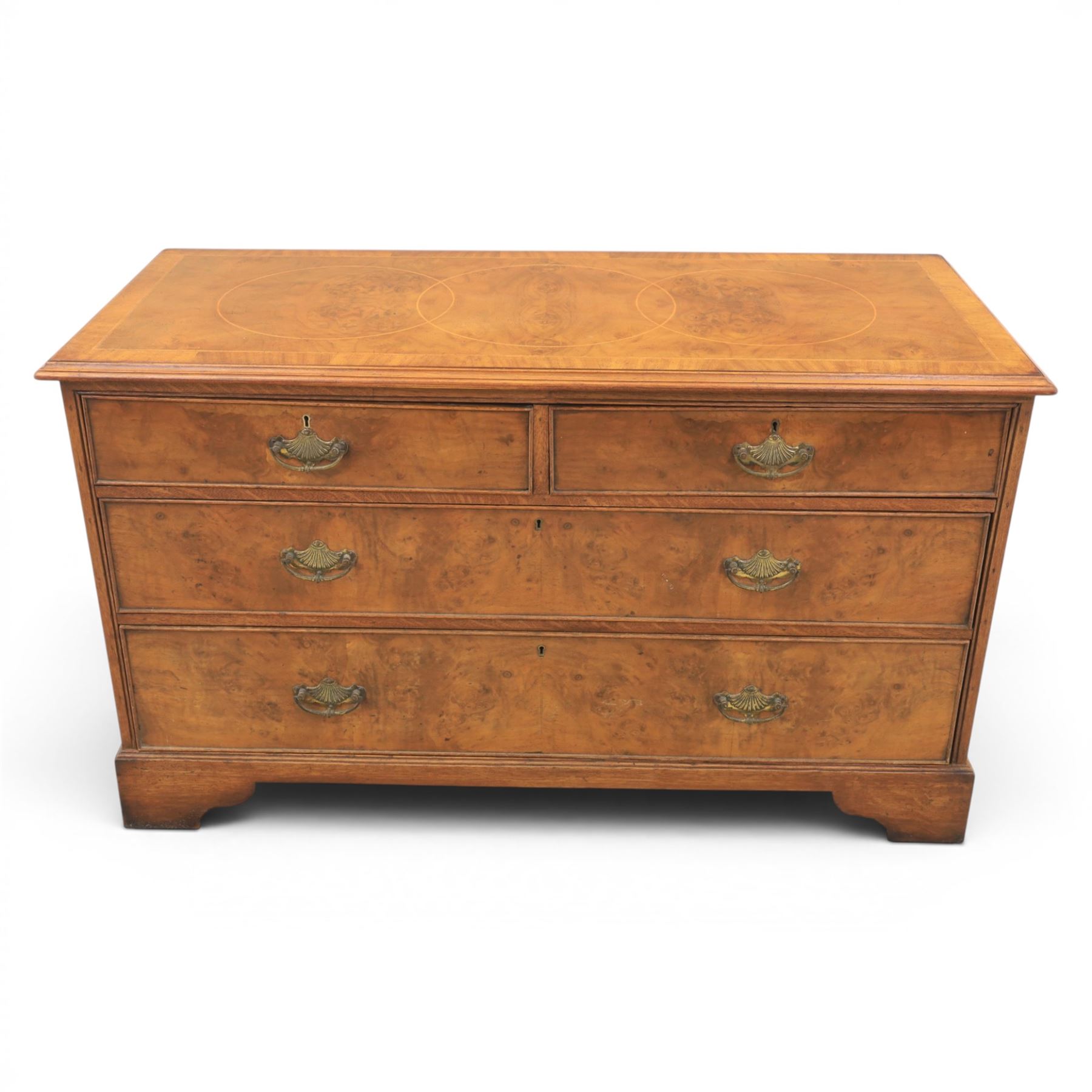 Traditional design walnut inlaid chest, with figured top with circular inlay and crossbanded top with moulded edge, figured drawers with cockbeaded edges and brass handles, raised on bracket feet