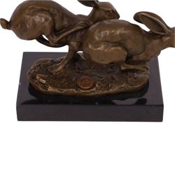 Bronze figure group, modelled two hares in chase, upon naturalistically modelled oval base signed Nick and with foundry mark, raised upon black marble base, H11cm L12.5cm