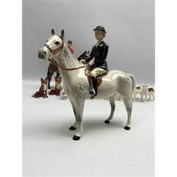 Beswick hunting group, comprising huntswoman on grey horse no 1730, huntsman on brown horse no 1501, two seated fox figures no 1748 and seven fox hounds, all with printed marks beneath (11)