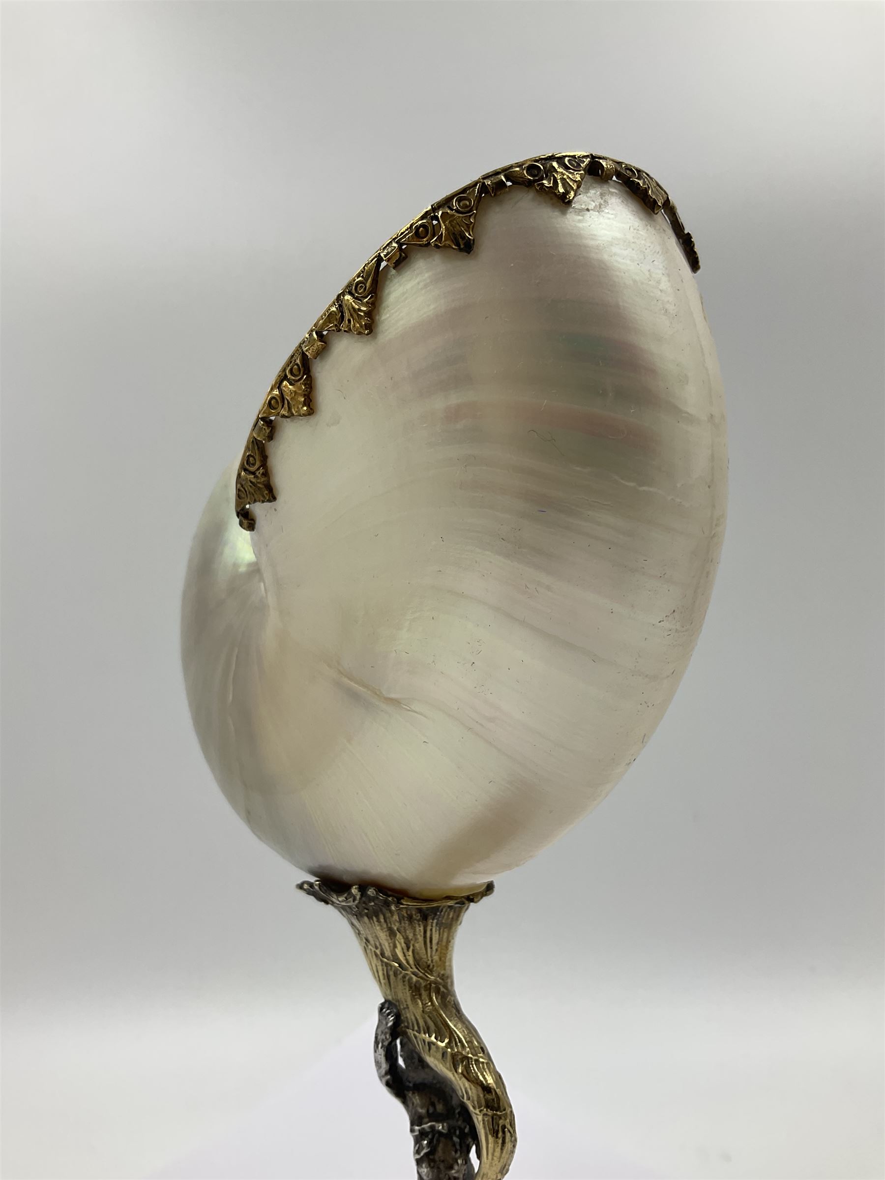 Modern limited edition silver mounted nautilus shell cup, no. 42/150, the pearlescent shell cup with silver-gilt strapwork to rim, upon a stem modelled as a putto supporting a gilt cornucopia and circular domed foot depicting Poseidon amongst swirling waves, hallmarked by St James House Company, London 1980,  H17.5cm