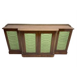 19th century mahogany break-front sideboard, raised brass gallery back with Greek key design, fitted with four cupboard doors, their pleated green fabric overlain with gilt metal grilles, lower moulded edge over plinth base