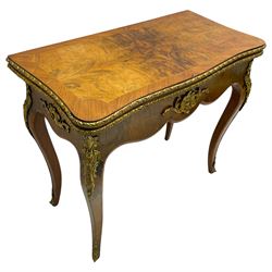 20th century French walnut and Kingwood card table, shaped fold-over top with figured quarter-matched veneers and floral egg and dart moulded edge in gilt metal, shaped aprons decorated with shell motifs with extending foliage, pull-out action base revealing storage well, on cabriole supports with ornate gilt metal mounts 