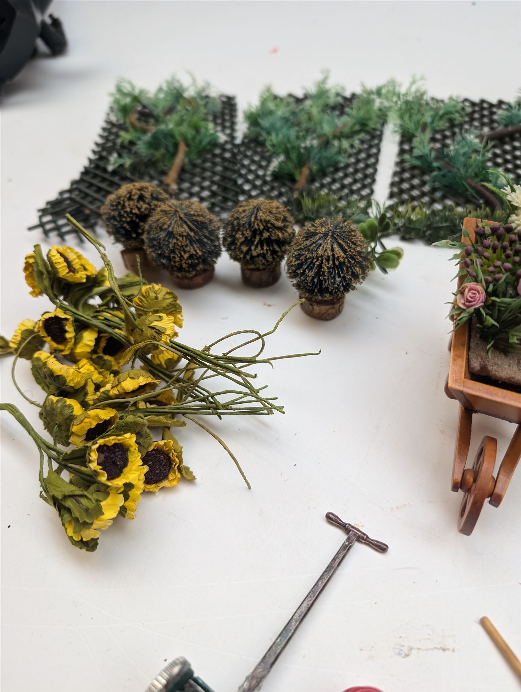 1:12 scale dolls house allotment and garden accessories, including wooden shed on a stone effect base, two vegetable patches, terracotta plant pots with flowers and foliage, stone effect plant pots, other planters, loose sunflowers, scarecrow, rabbit hutch, garden tools, fencing panels, etc 