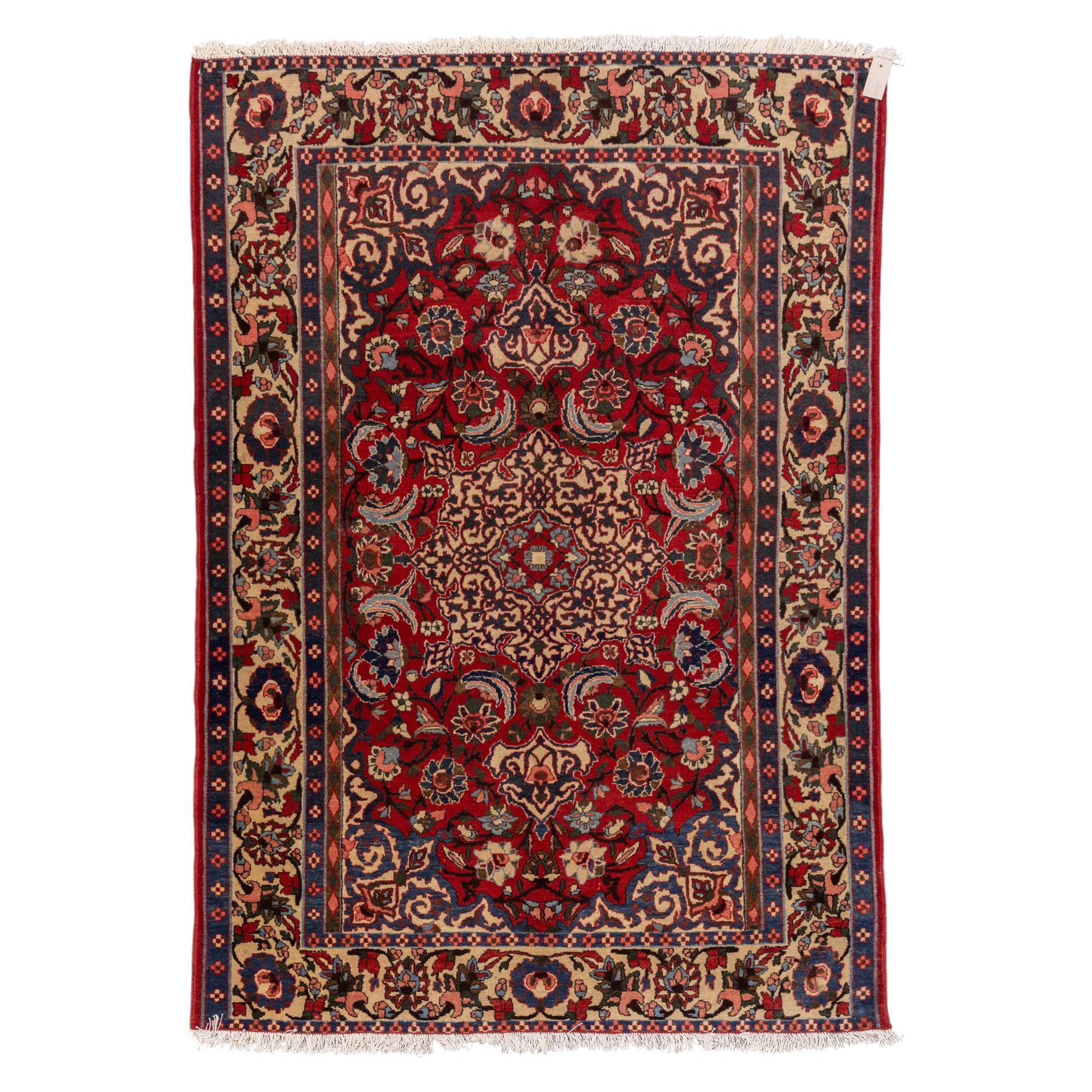 Central Persian Isfahan hand-knotted rug, madder red field, with elaborate central medallion with pendants and scrolling arabesques, palmettes and stylized floral sprays arranged in a densely ornamented ground of classical Safavid inspiration, ivory border with a continuous vine scroll of palmettes and rosettes, flanked by multiple guard stripes in navy and red with geometric and floral motifs, with cotton fringe ends 