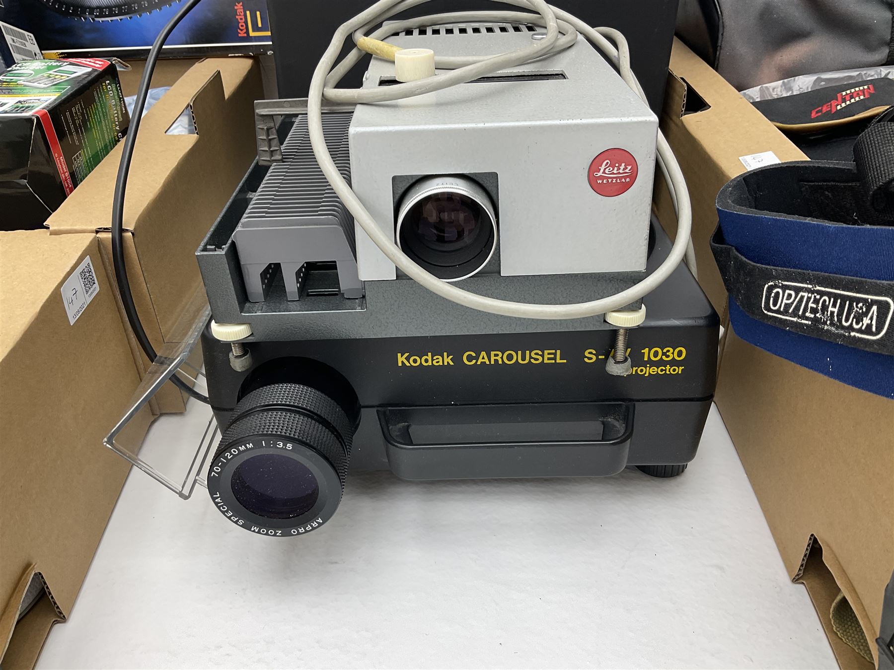 Large quantity of camera equipment in three boxes - Lumix GX1 camera, Canon EOS 500 camera, Lumix FZ100 camera, Pantax  MZ5n, various other cameras, Swift spotting Scope 20 x 60 in box,  Maxtor hard drive, three tripods, Kodak carousel projector, Pradolux slide projector, a selection of camera bags and other camera equipment. 