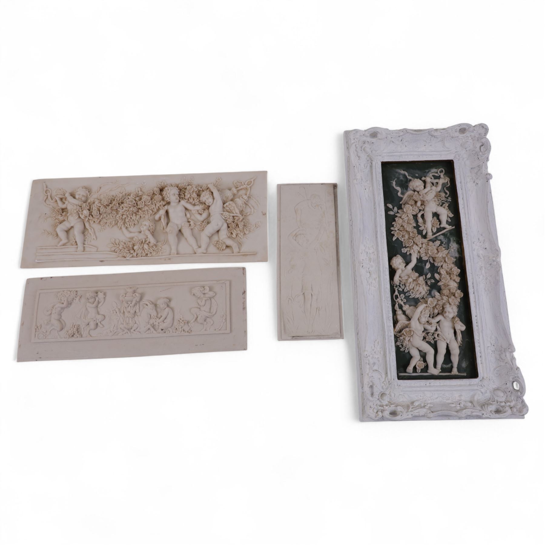 Composite plaque decorated in relief with putti amongst flowering roses, together with similar framed example and two others, framed H56cm, W28cm