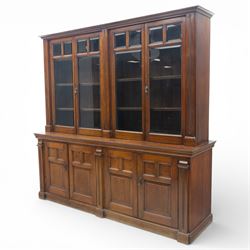 Late 19th century walnut library bookcase, fitted with four display doors with astragal bevelled panes, raised upon a four cupboard base with fielded panel doors