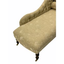 Victorian style chaise longue, upholstered in pale ground fabric decorated with raised foliate pattern design, with bolster cushion, on turned supports with castors