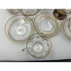 Collection of eleven pieces of French gilded glassware comprising pair of flattened lozenge form decanters with stoppers, pair of cups and saucers, pair of wavy rim vases, two wine glasses, one with replacement hallmarked silver pedestal and frilled rim globular vase (11)