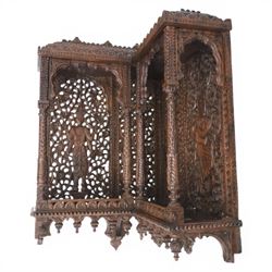 20th century Indian carved hardwood corner shelf, the tiered pagoda form with pierced and carved foliate panels centred by figural carving, supported by turned and carved columns, with shaped brackets and pendant finials