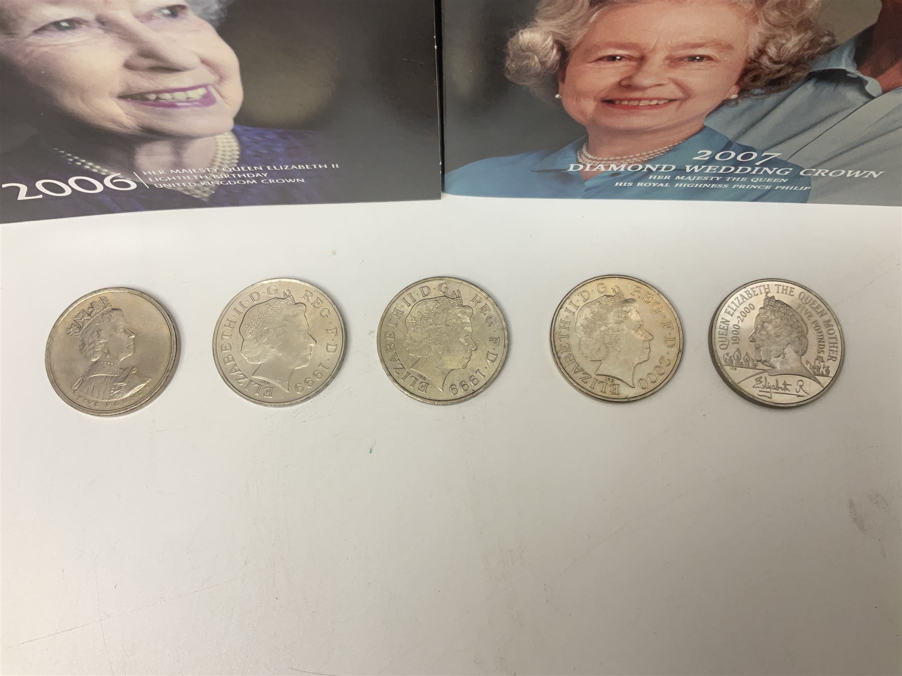 Seven Queen Elizabeth II United Kingdom five pound coins, including 2006 and 2007 in card folders, etc. 