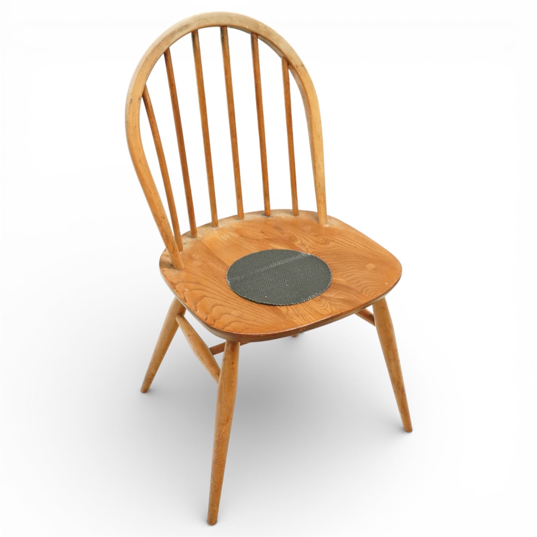 Ercol - elm dining chairs, a set of five comprising four side chairs and one '370' armchair, all with hoop backs formed with slender spindle splats, shaped solid elm seats, the armchair with curved out-swept arms, raised on splayed turned supports united by stretchers